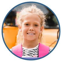 Portfolio photo of a young girl in front of a school bus