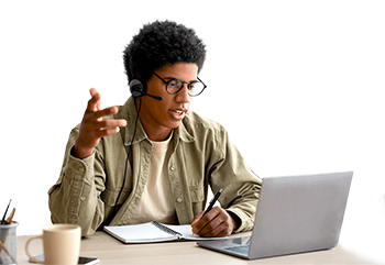 A young man using headset mic to talk into laptop